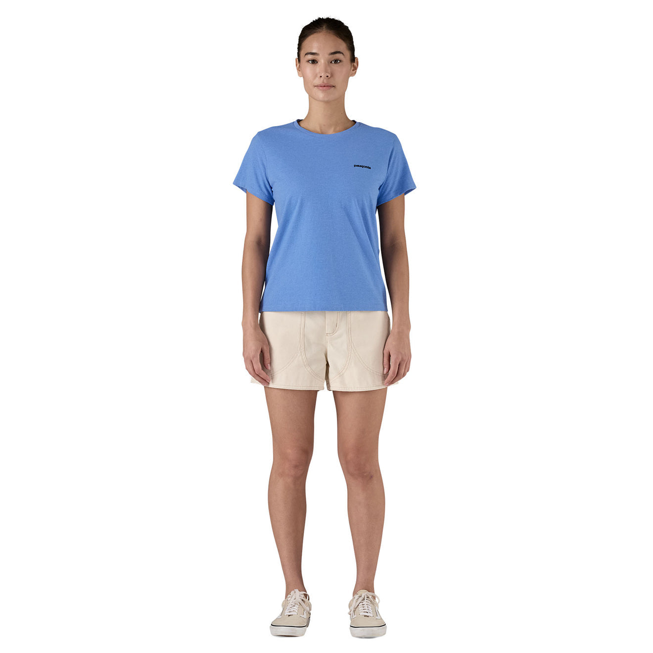Woman wearing blue Patagonia P-6 Logo Responsibili-Tee with beige shorts