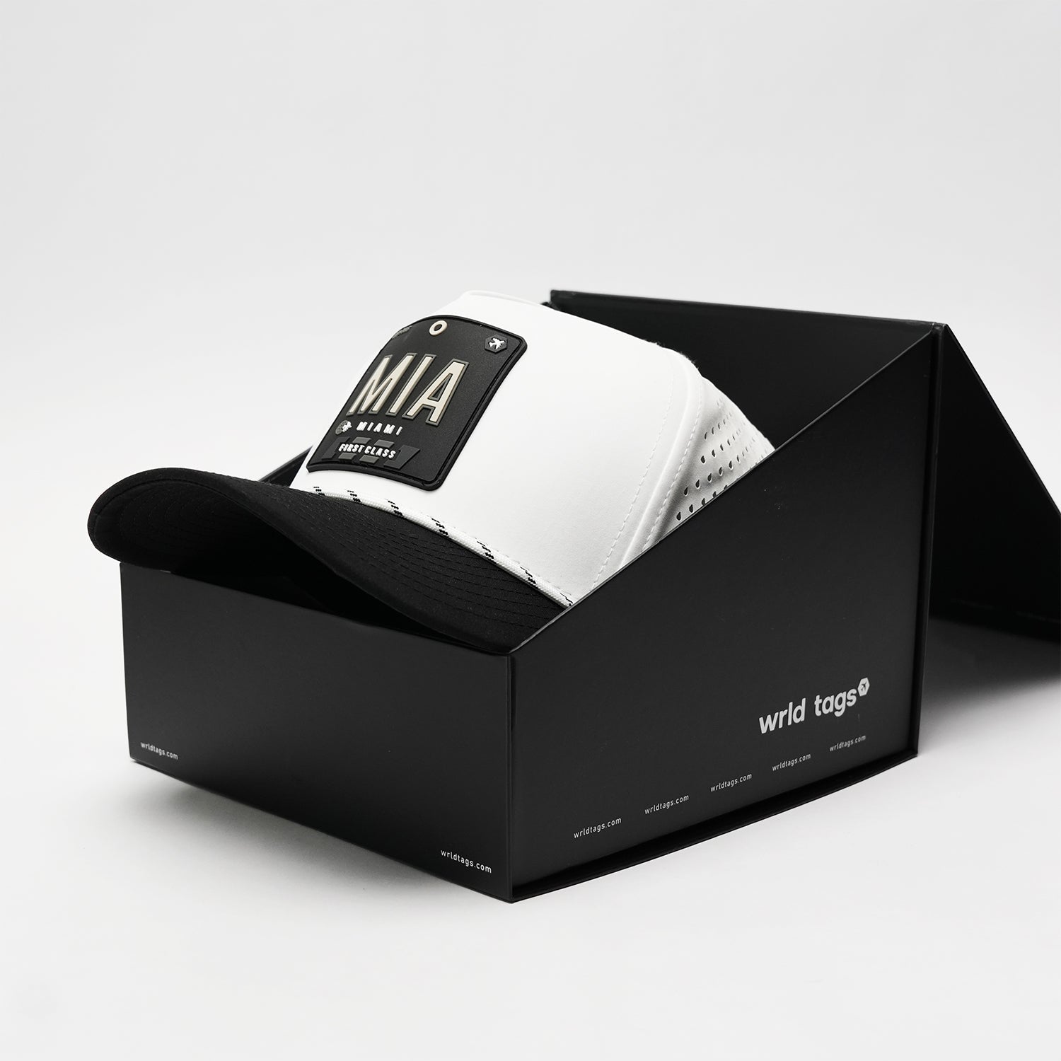 White and black Miami trucker hat by Wrld Tags in black packaging box