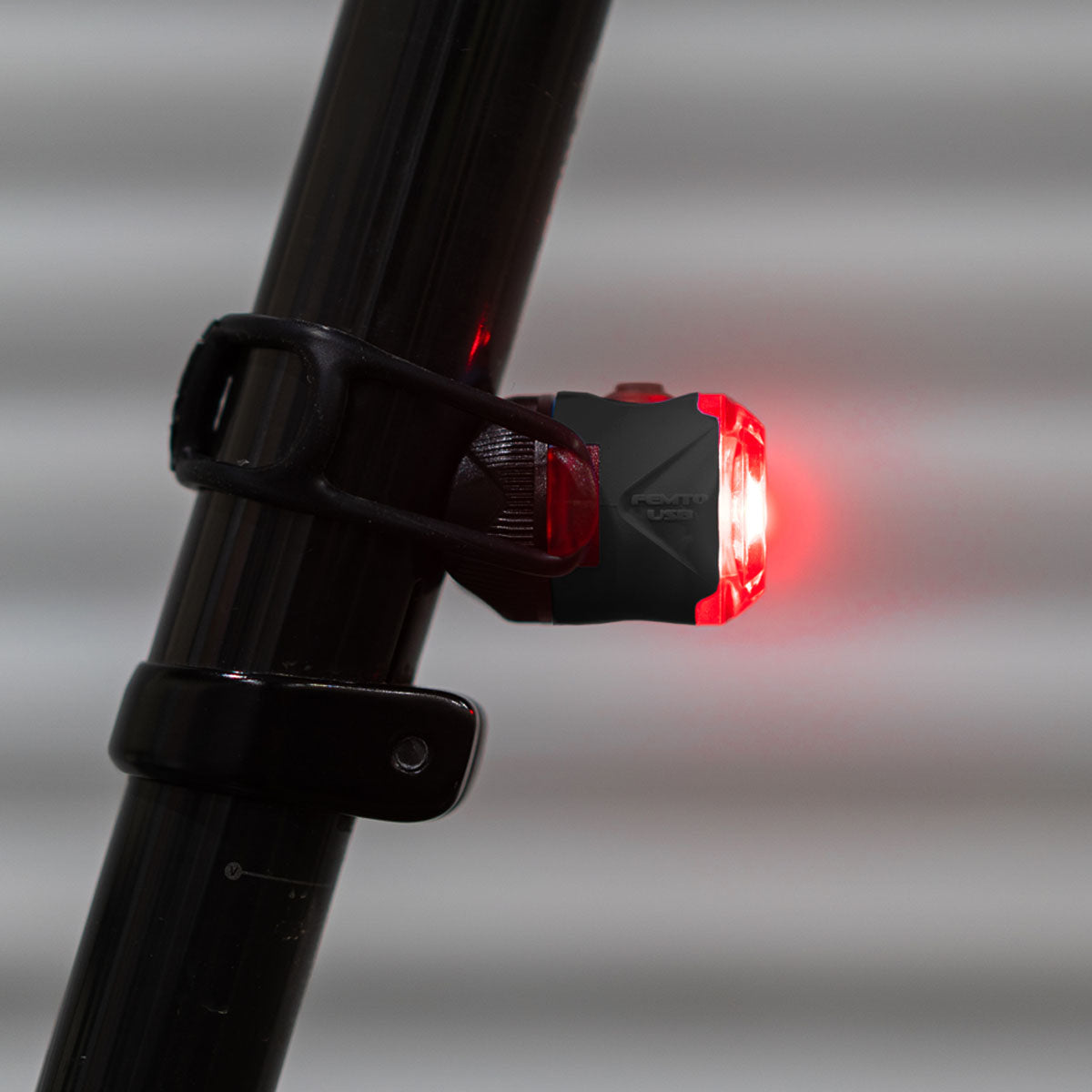 Lezyne FEMTO USB C Drive rear bike light in black mounted on bicycle frame with red LED illuminated