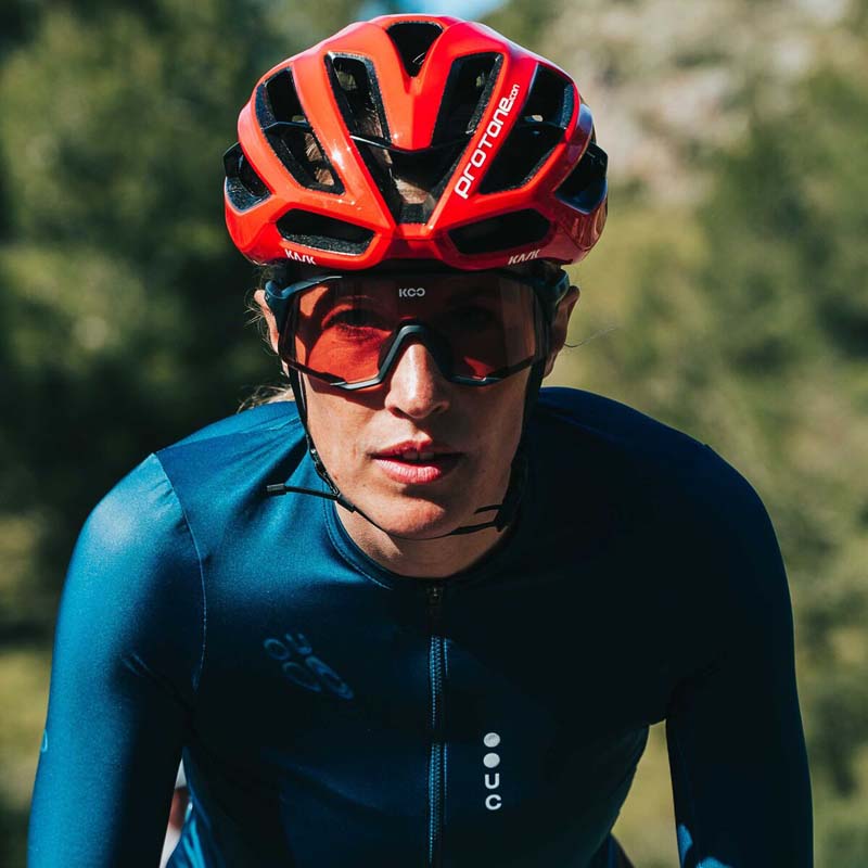 Cyclist wearing red Kask Protone helmet with aerodynamic design and ventilation slots