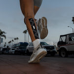 RockTape GO Reflective black kinesiology tape with white dots on runner's calf