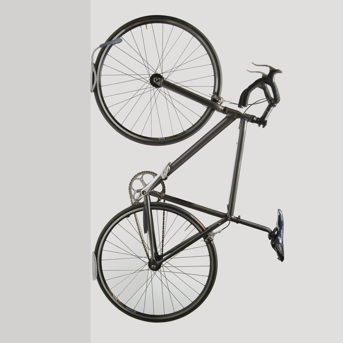 Delta grey wall mount bike rack holding bicycle vertically against white background
