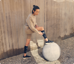 Woman wearing black Therabody RecoveryPulse calf compression sleeves during outdoor workout