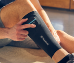 Person wearing Therabody compression calf sleeve on leg in professional lifestyle shot