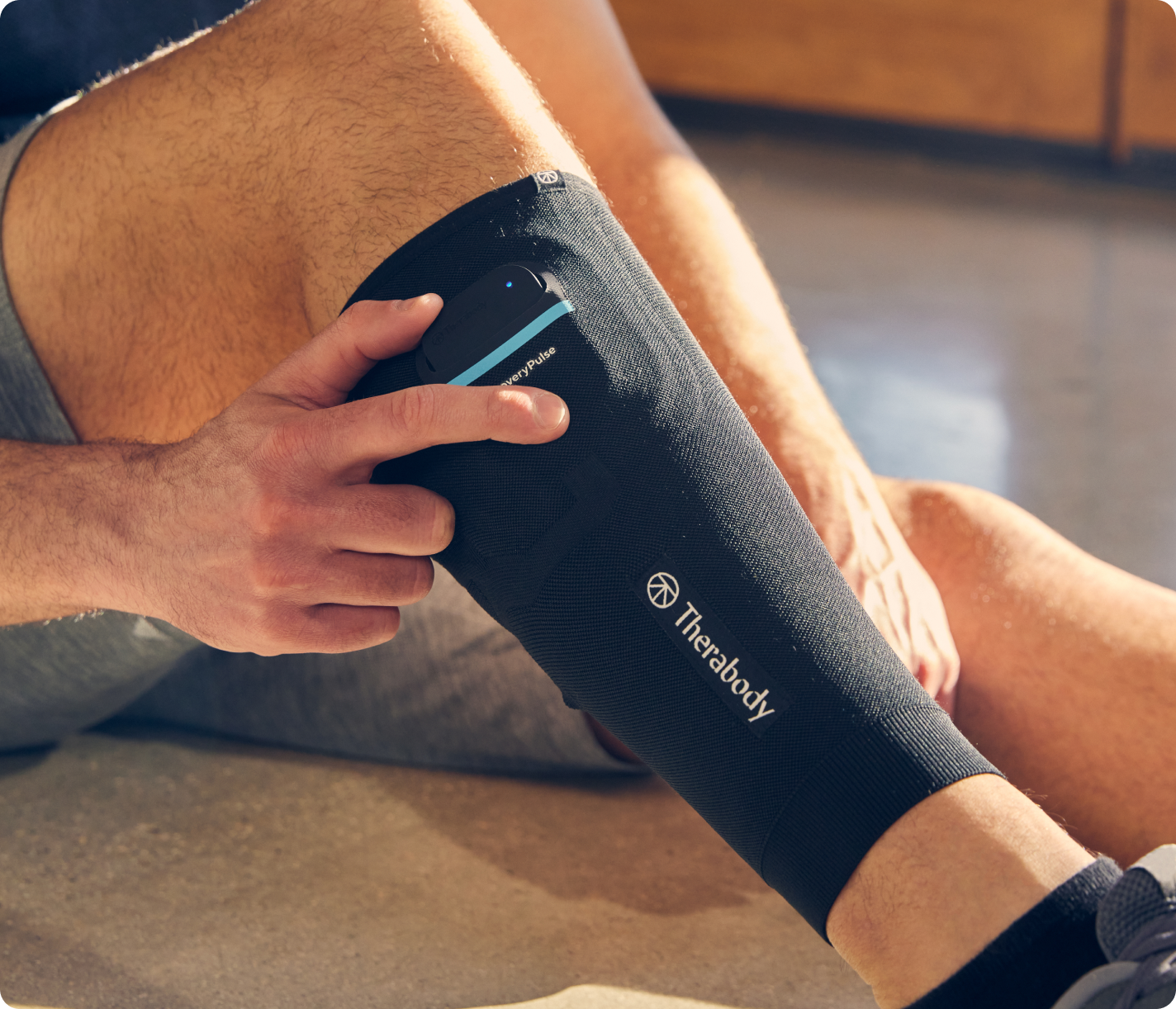 Person wearing Therabody compression calf sleeve on leg in professional lifestyle shot