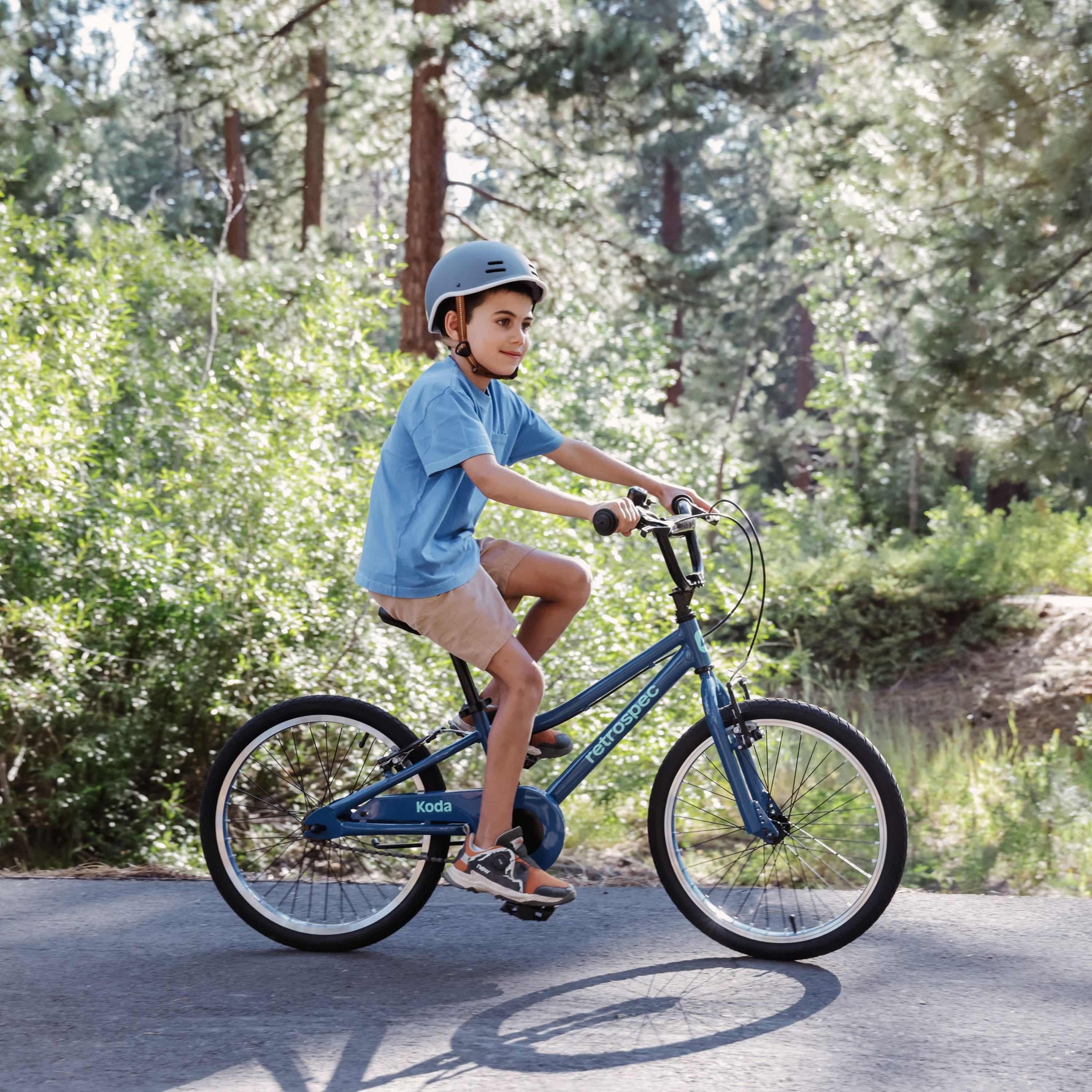 Child riding Retrospec Koda kids bike in overcast blue on outdoor path