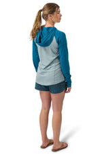 Woman wearing Flylow Gear Moonlight hooded shirt in cloud blue colorblock design