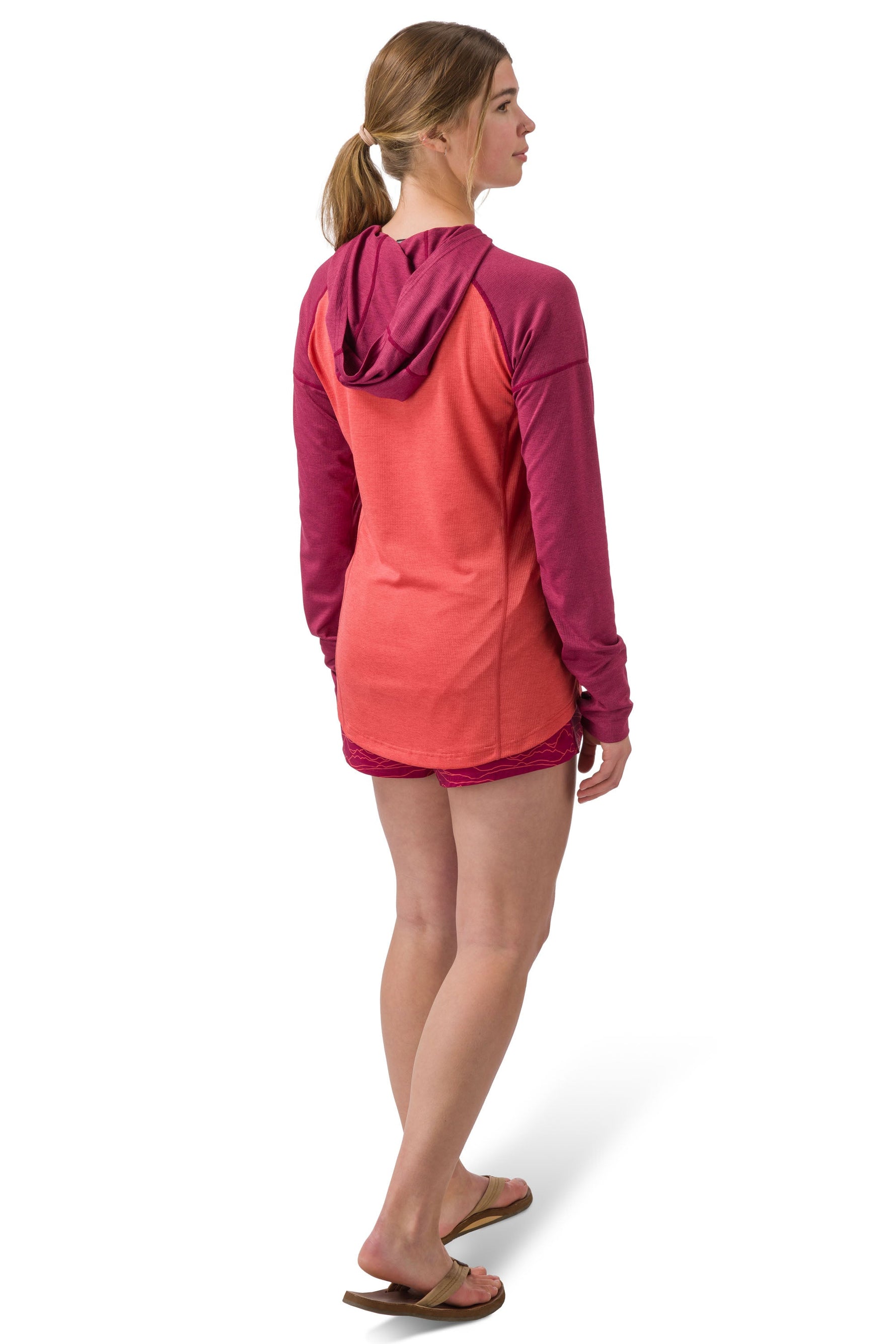Woman wearing coral and purple hooded long-sleeve shirt viewed from behind