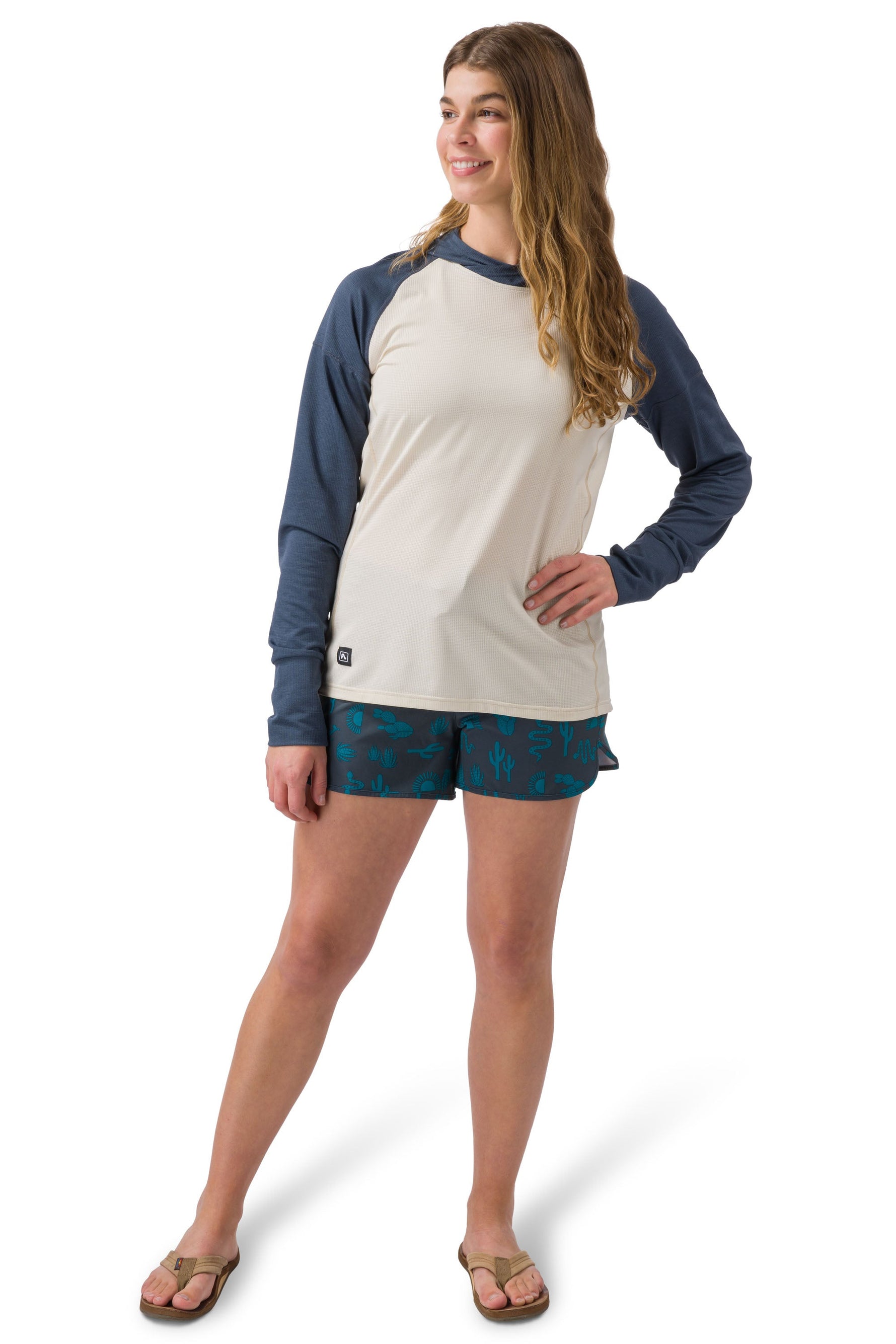 Woman wearing Flylow Moonlight raglan hoodie in cloud colorway with navy sleeves