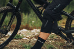 DAKINE black knee sleeve worn by cyclist on mountain bike trail