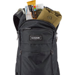 Black Dakine Syncline 12L backpack with contents showing organized storage compartments