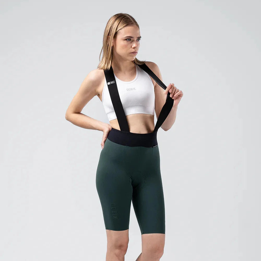 Woman wearing Gobik X Bib Short in dark green with white sports bra