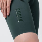 Close-up of Gobik women's cycling shorts in dark green showing logo detail