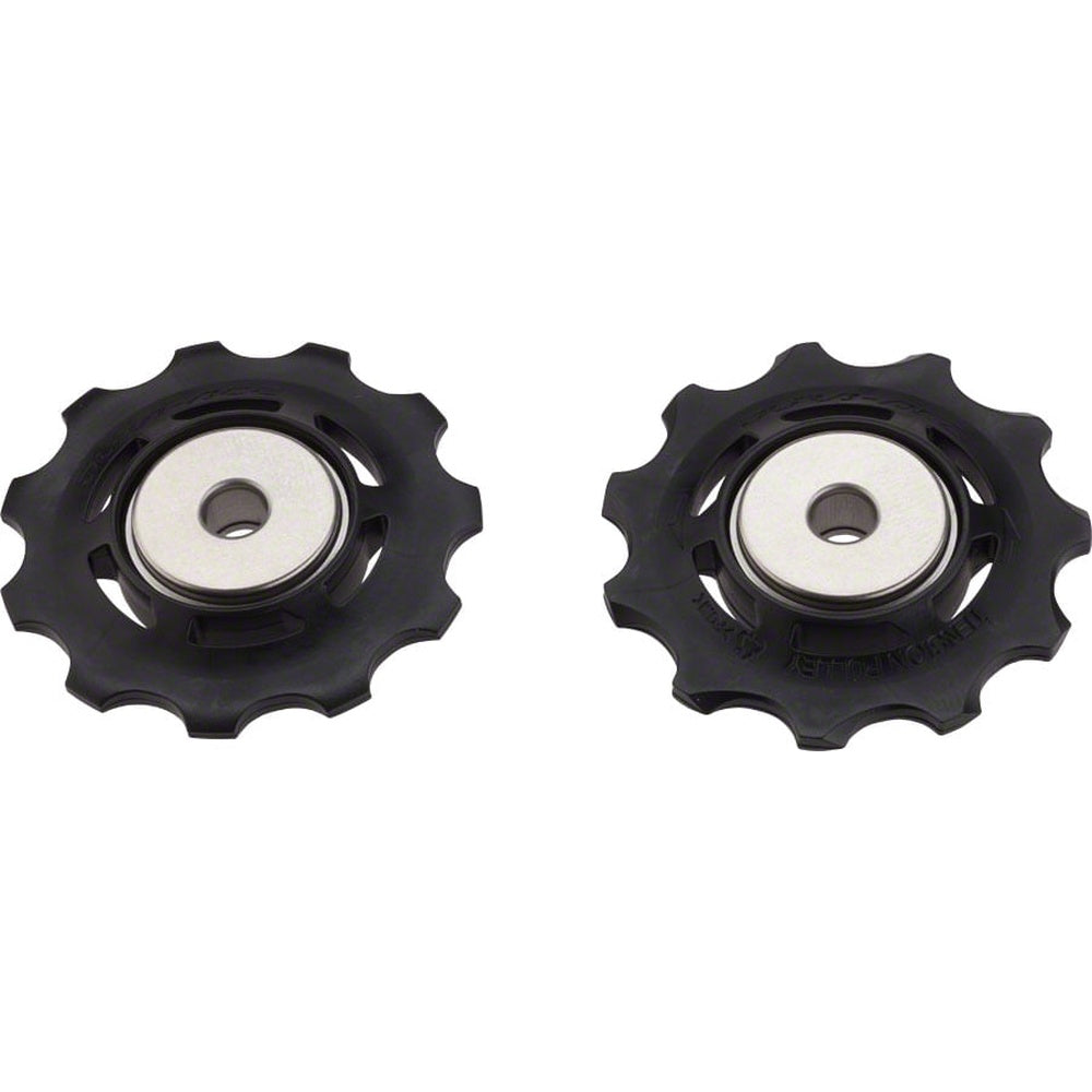 Two black Shimano derailleur pulleys with silver bearings on white background