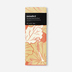 Nomadix towel in cream with orange floral hibiscus pattern, packaged presentation