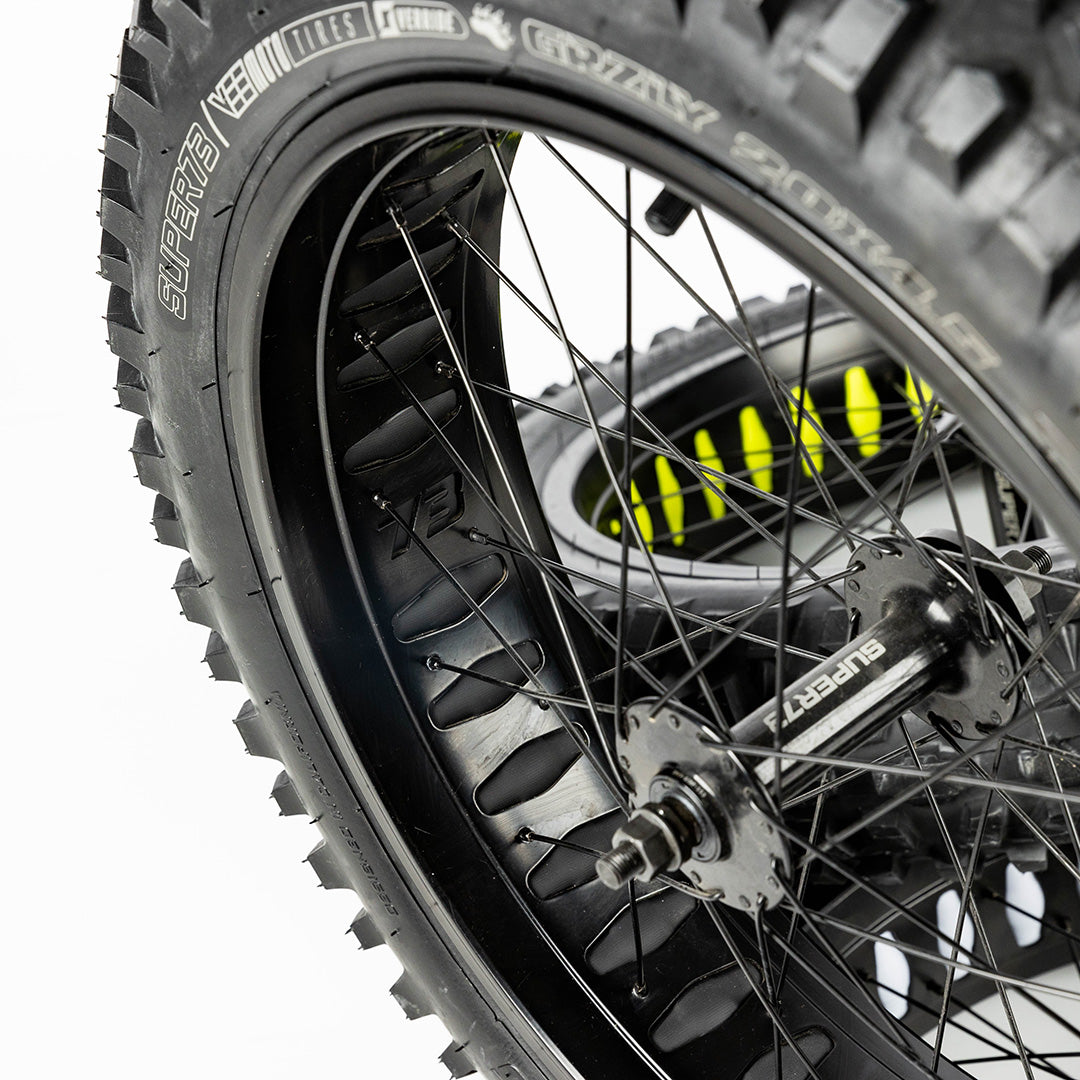 Super73 yellow wheel liner installed on black spoked bicycle wheel