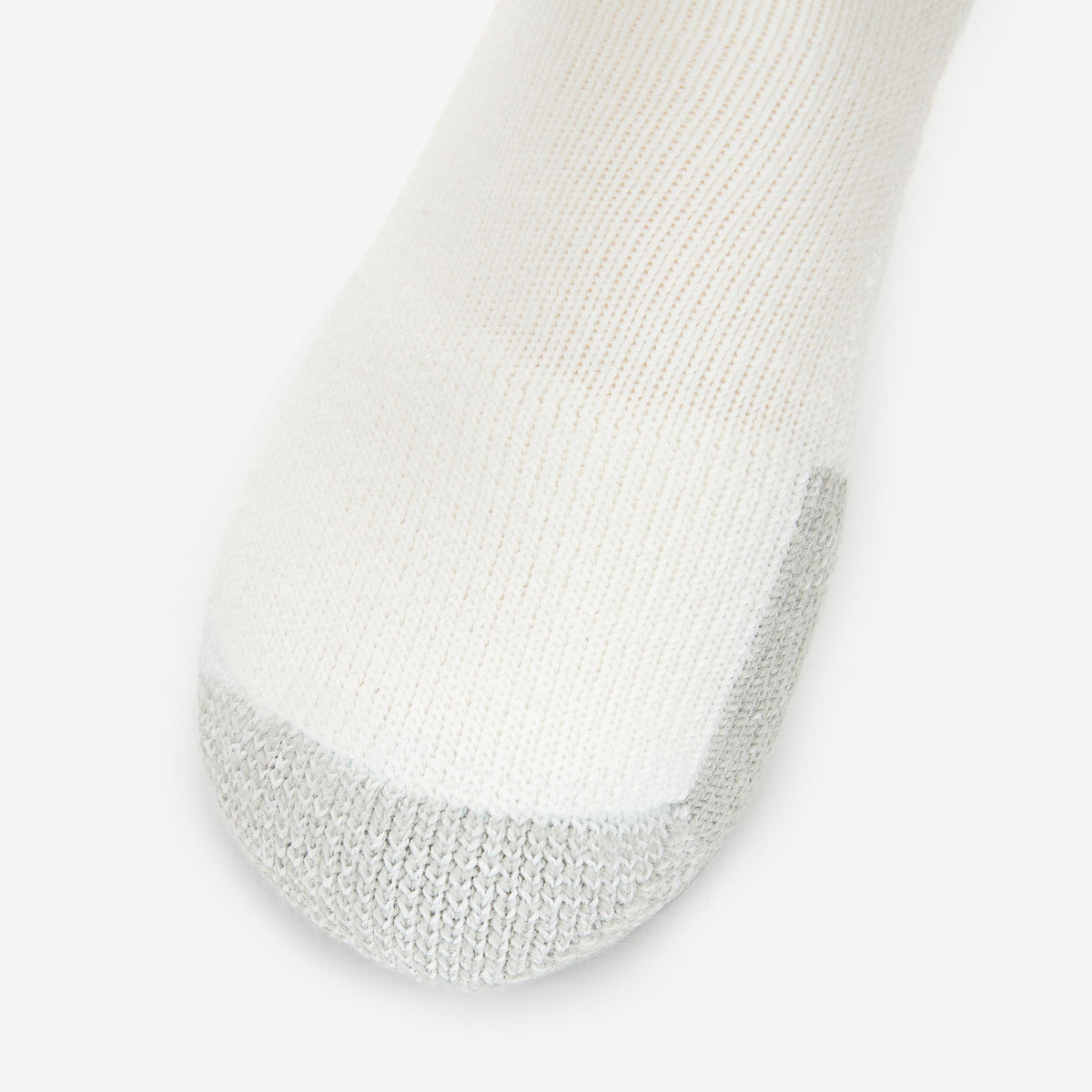 Thorlos white tennis sock with gray reinforced toe cushioning on clean background