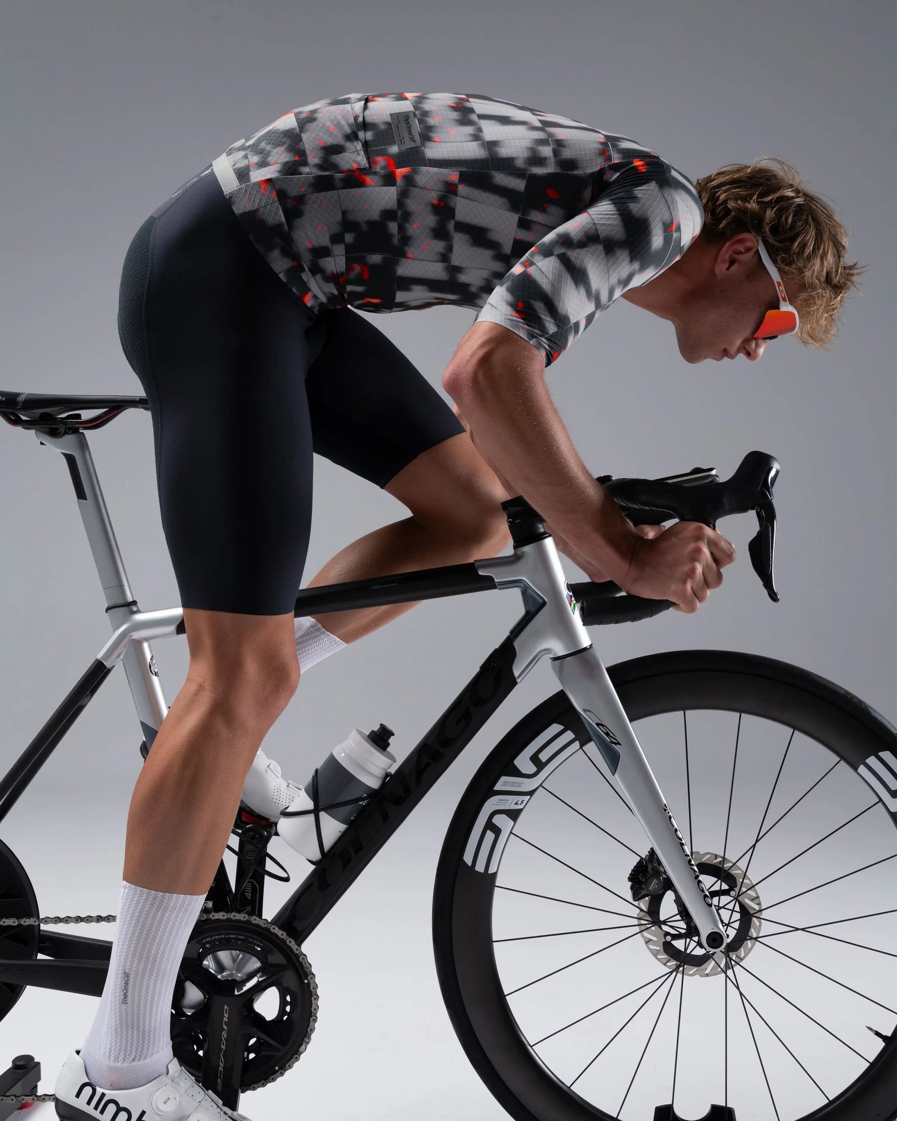 Cyclist in aerodynamic position wearing TheOneOff Krypton Short Sleeve Jersey in Phosphorus colorway