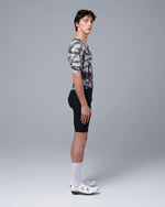 Side profile view of male model wearing TheOneOff Krypton cycling jersey with bib shorts