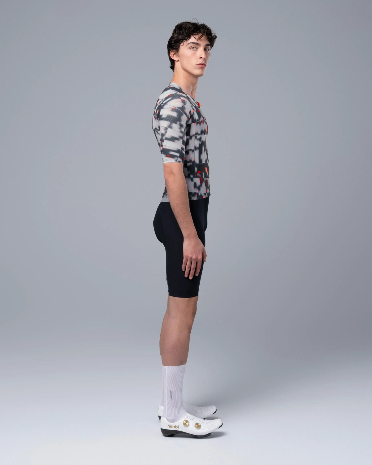 Side profile view of male model wearing TheOneOff Krypton cycling jersey with bib shorts