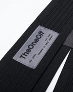 Close-up detail of TheOneOff branded label on Xenon Bib Short black shoulder strap