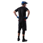 Man wearing black Troy Lee Designs cycling shorts with liner and helmet
