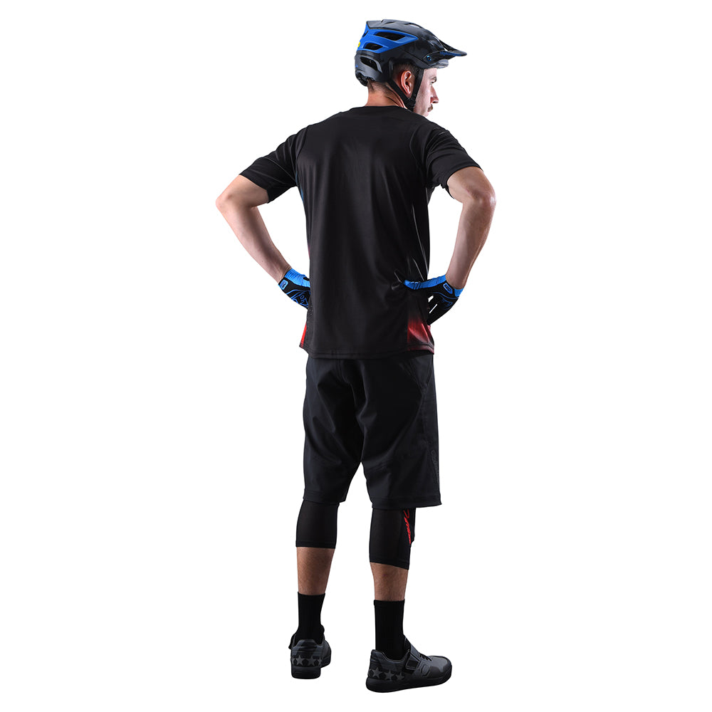 Man wearing black Troy Lee Designs cycling shorts with liner and helmet