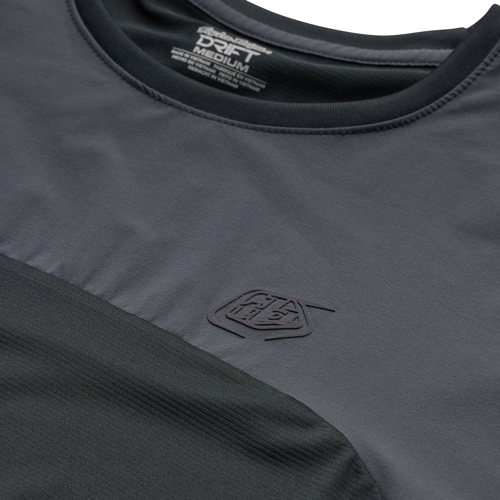 Troy Lee Designs Drift SS Jersey in Dark Charcoal showing embossed logo detail