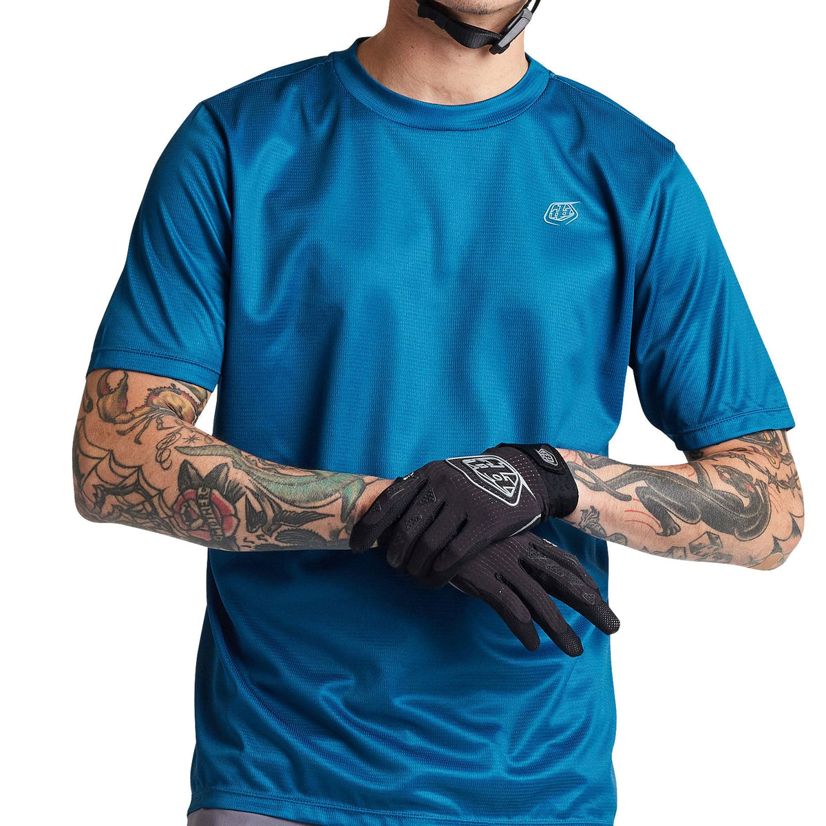 Troy Lee Designs Flowline Jersey in slate blue worn by tattooed male model with cycling gloves