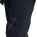 Close-up of Troy Lee Designs black cycling shorts showing knee padding detail
