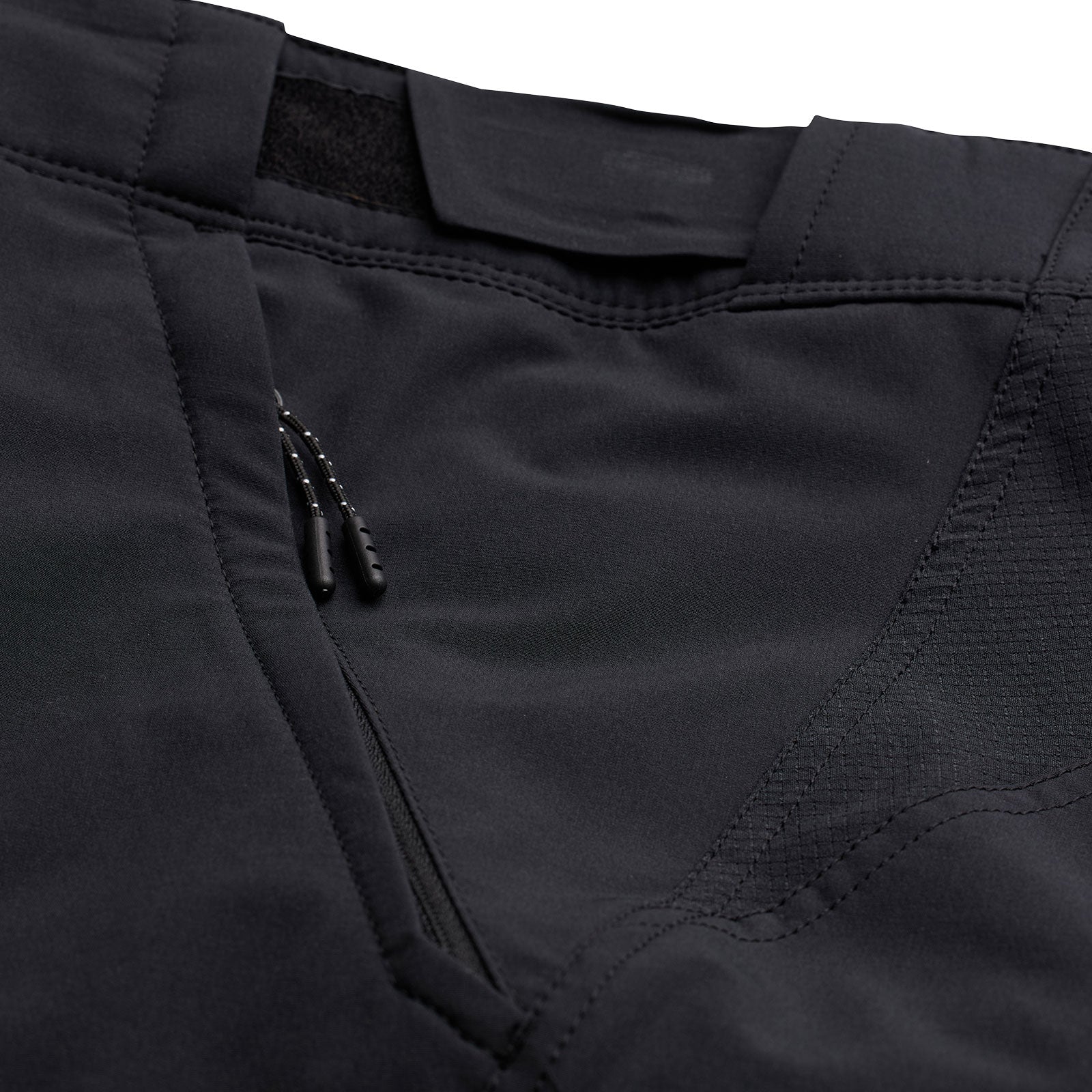 Close-up of black Troy Lee Designs cycling shorts showing pocket detail and stitching