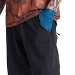 Troy Lee Designs black cycling shorts with blue gloves and camo shirt detail