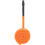 Orange Tubolito bicycle inner tube with black valve stem, coiled and displayed vertically