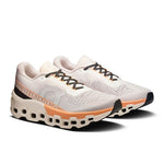 On Cloudmonster 2 women's running shoes in ivory and tangerine colorway, pair view
