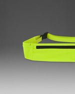 2XU Run Belt in bright volt yellow with black zipper on gray background