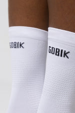 Close-up of white Gobik socks with brand logo on ankle cuff