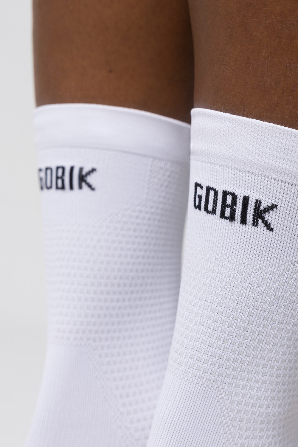 Close-up of white Gobik socks with brand logo on ankle cuff
