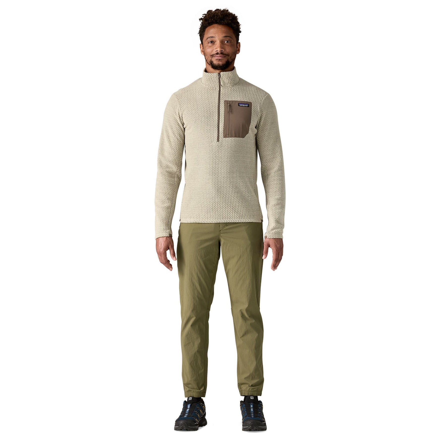 Man wearing Patagonia R1 Air Fleece zip-neck in pelican color with olive pants