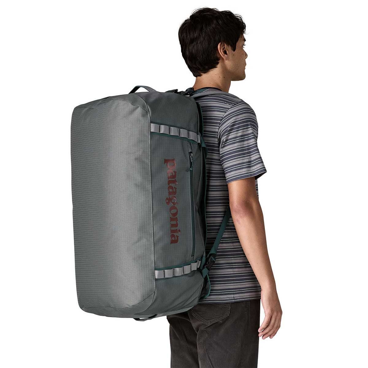 Man wearing Patagonia Black Hole Duffel 70L backpack in Noble Grey color
