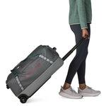 Person pulling Patagonia Black Hole Wheeled Duffel 70L in Noble Grey color