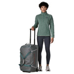 Woman with Patagonia Black Hole Wheeled Duffel 70L in Noble Grey