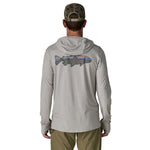 Man wearing Patagonia light grey hooded long sleeve shirt with colorful fish graphic on back