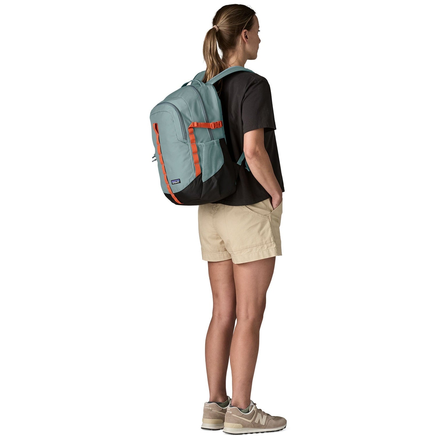 Woman wearing Patagonia Refugio Day Pack 26L in blue sage color from behind