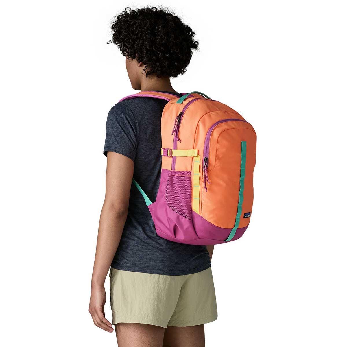 Woman wearing colorful Patagonia Refugio backpack with orange top and magenta bottom