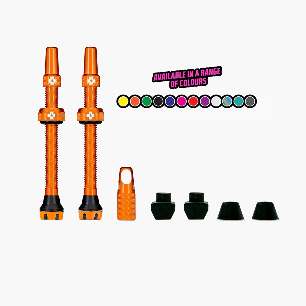 Orange Muc-Off tubeless valve kit with valves and accessories on white background