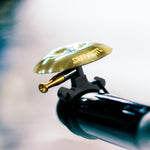 Lezyne Classic Shallow brass bicycle bell with black mounting hardware and threaded adjustment