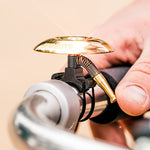 Lezyne Classic Shallow brass bicycle bell with black clamp mounted on handlebars