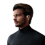 Man wearing white Shokz OpenFit Pro wireless earbuds in professional studio portrait