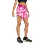 Woman wearing pink ChicknLegs split shorts with heart pattern and navy sports bra