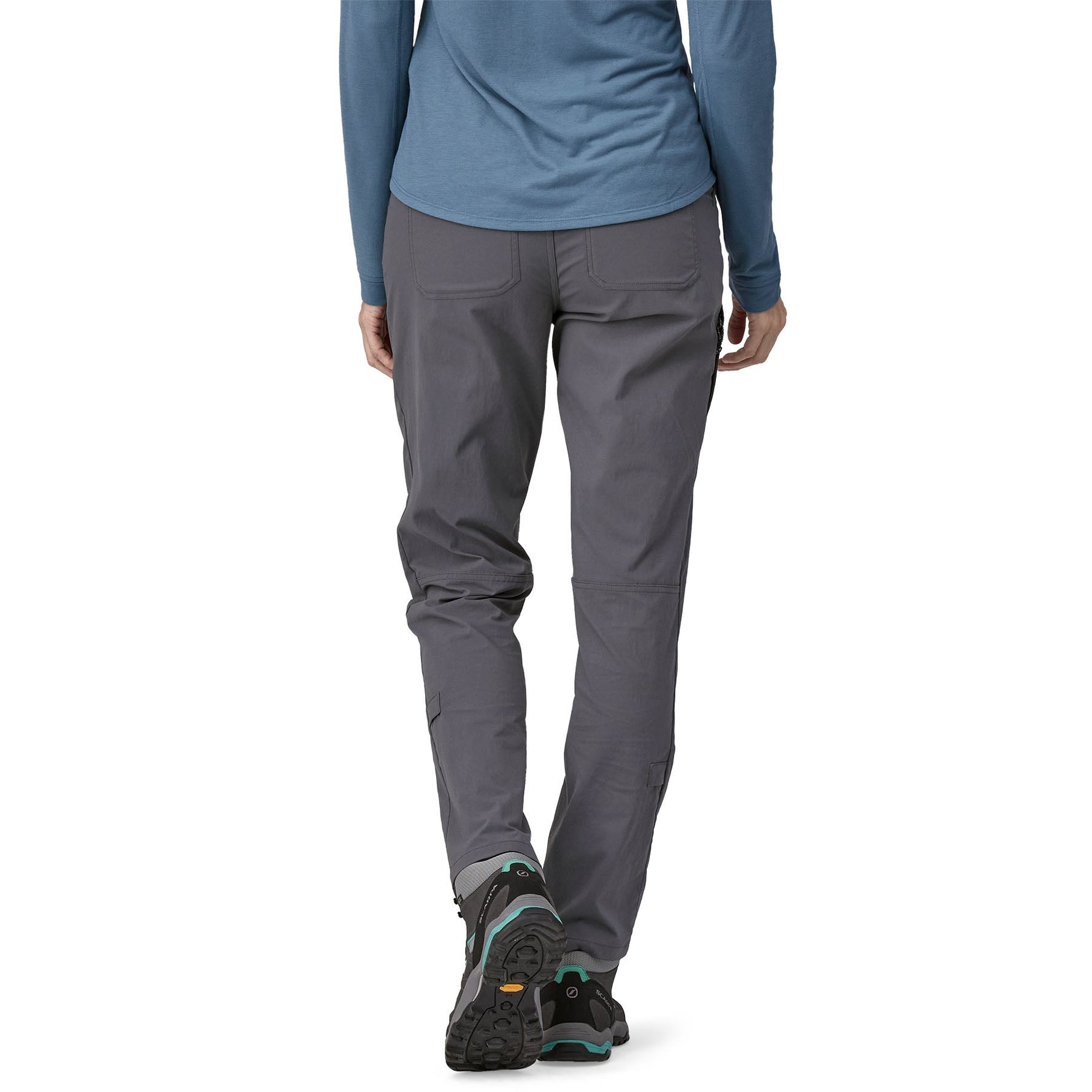 Woman wearing Patagonia Quandary pants in forge grey with hiking boots